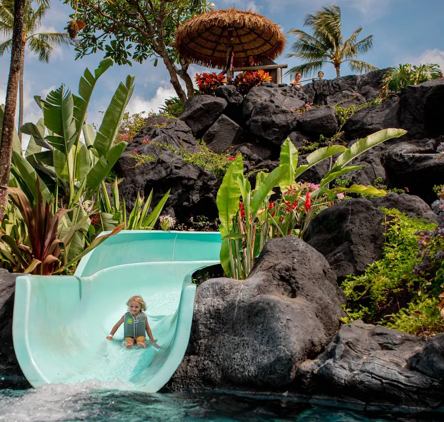 A child sliding down a waterslide at Grand Hyatt Kauai Resort & Spa
