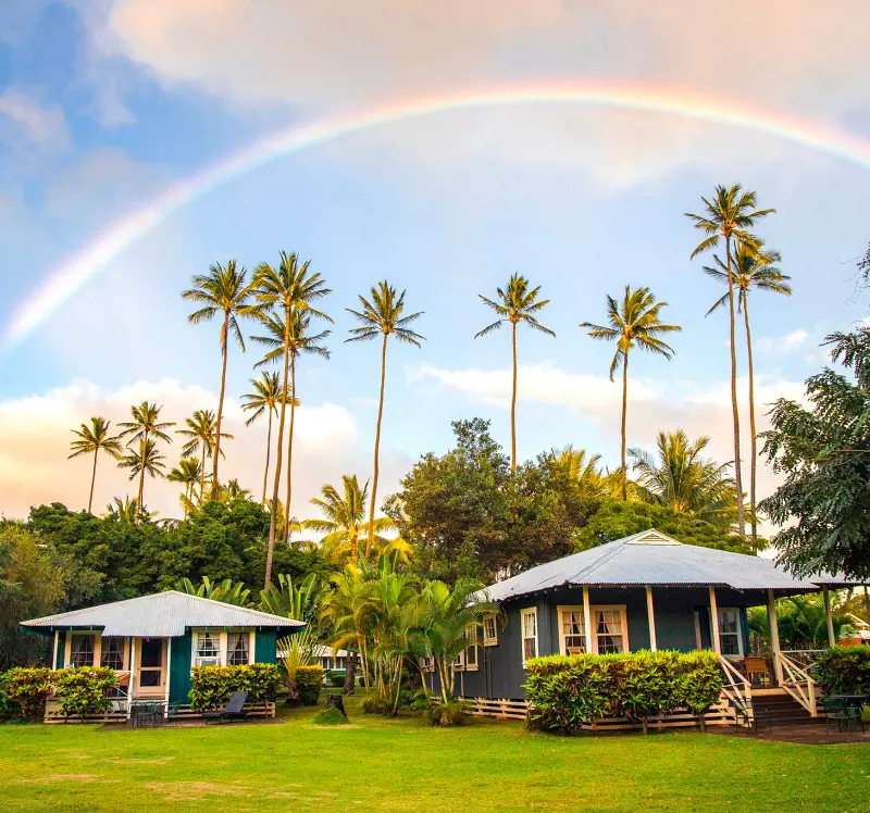 The beautiful buildings at Waimea Plantation Cottages with a rainbow in the background