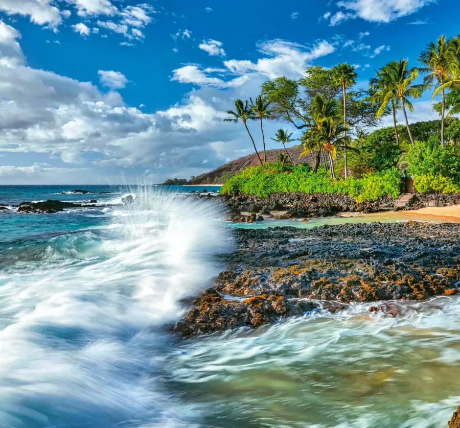 Waves crashing against the rocks on the shore of Secret Cove Beach in Maui, a photo by Victor Schendel Photography
