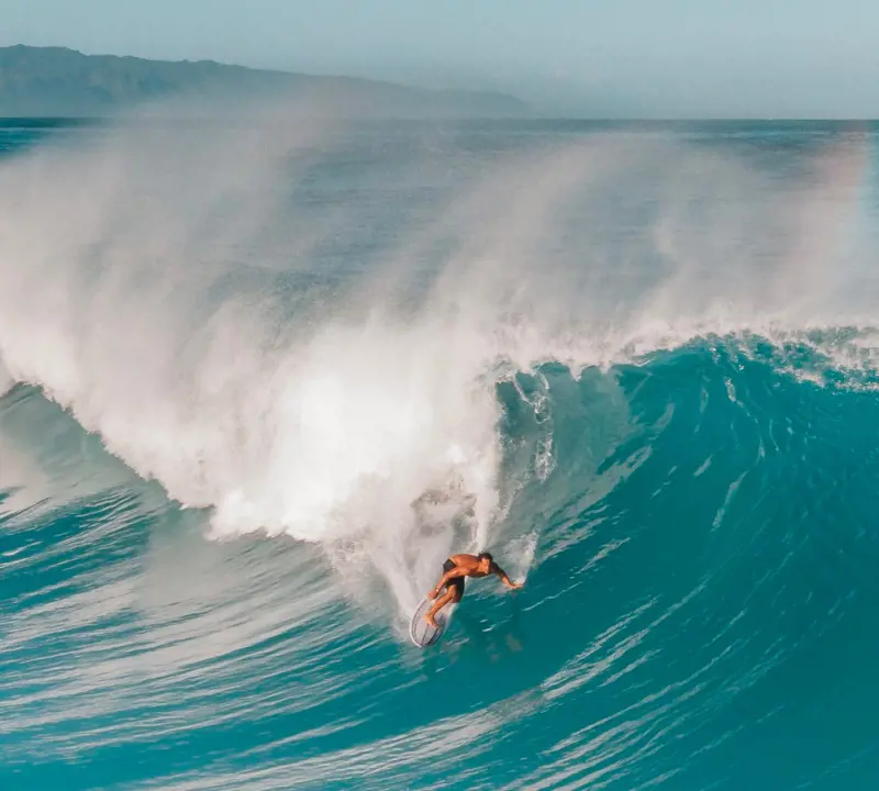 A spectacular scenes of giant waves at Banzai Pipeline and a pro surfer in action