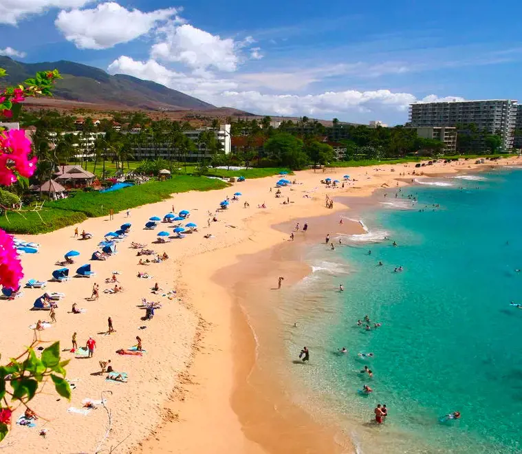 Tourists enjoying sunbathing and swimming on the Kaanapali Beach in Maui