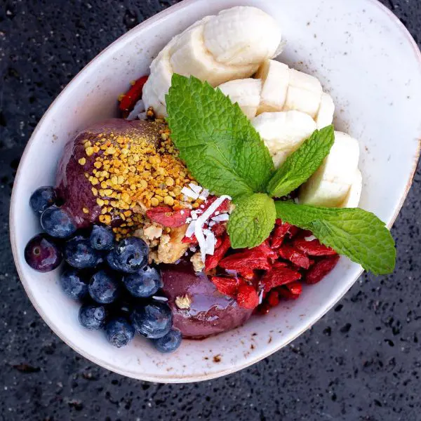 A delicious acai bowl featuring local honey, bananas and berries.